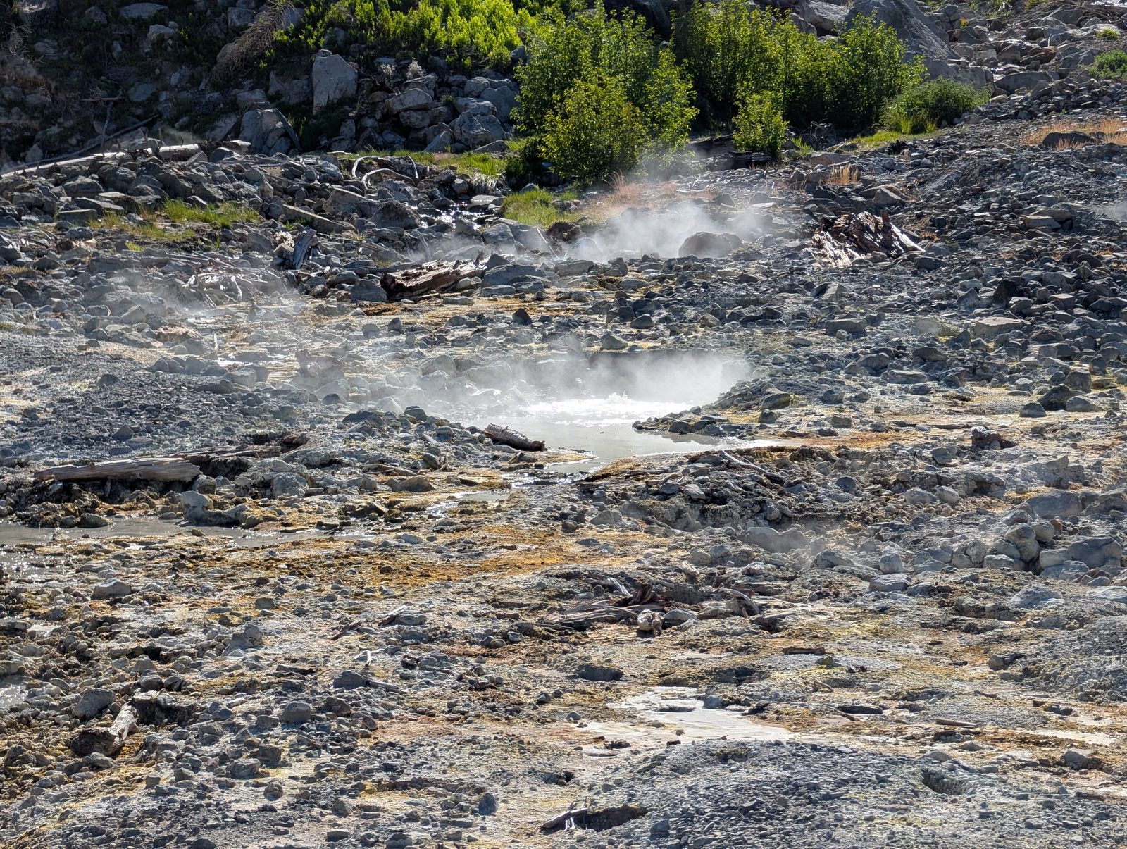 A steaming pool bubbling among rocks at the Bumpass Hell geothermal area
