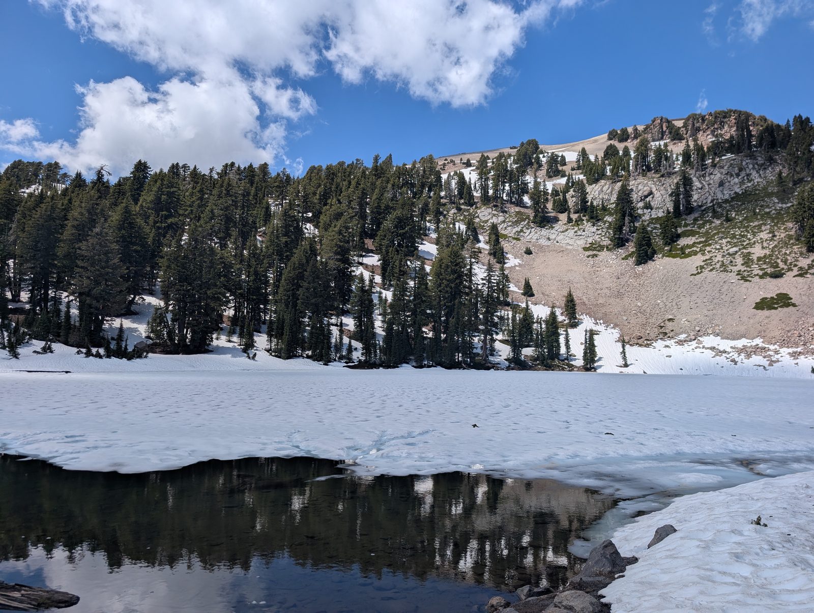 Another view of frozen Lake Helen with snow-covered slopes above the treeline