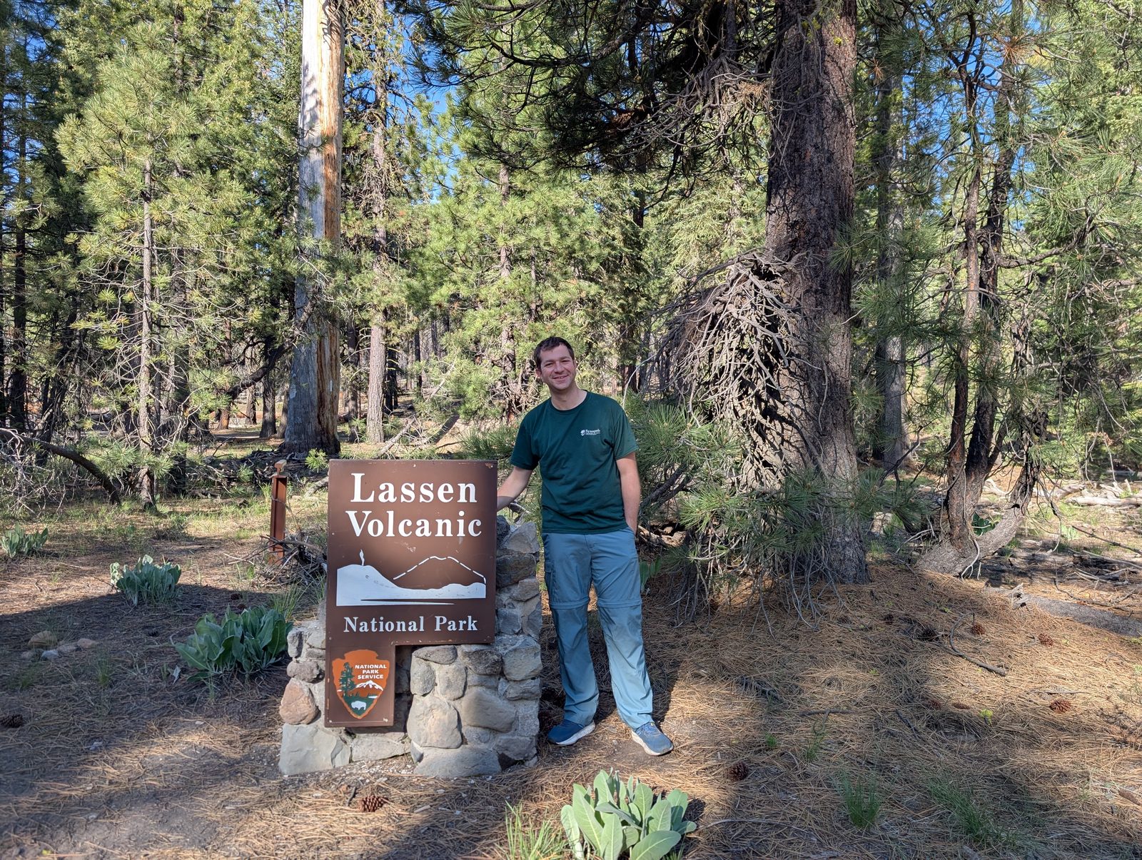 Standing next to the Lassen Volcanic National Park entrance sign