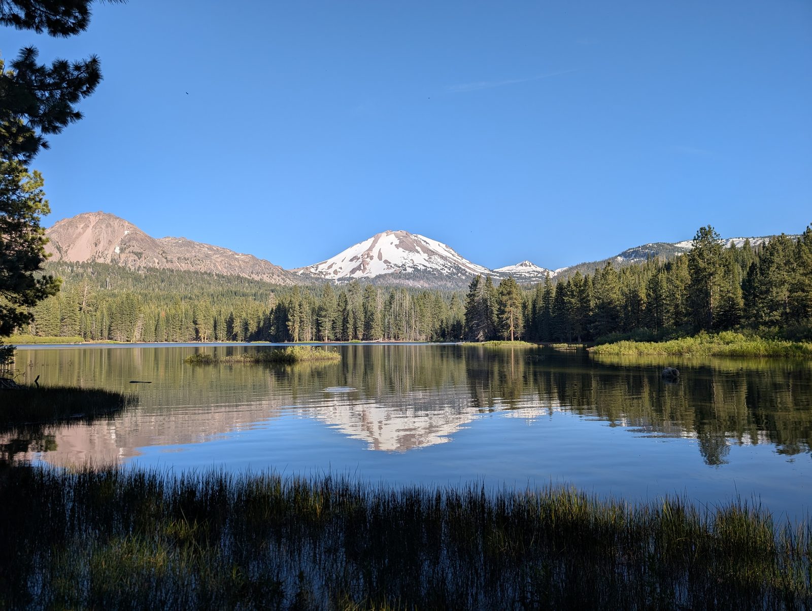 A second view of Lassen Peak mirrored in Manzanita Lake under a clear sky