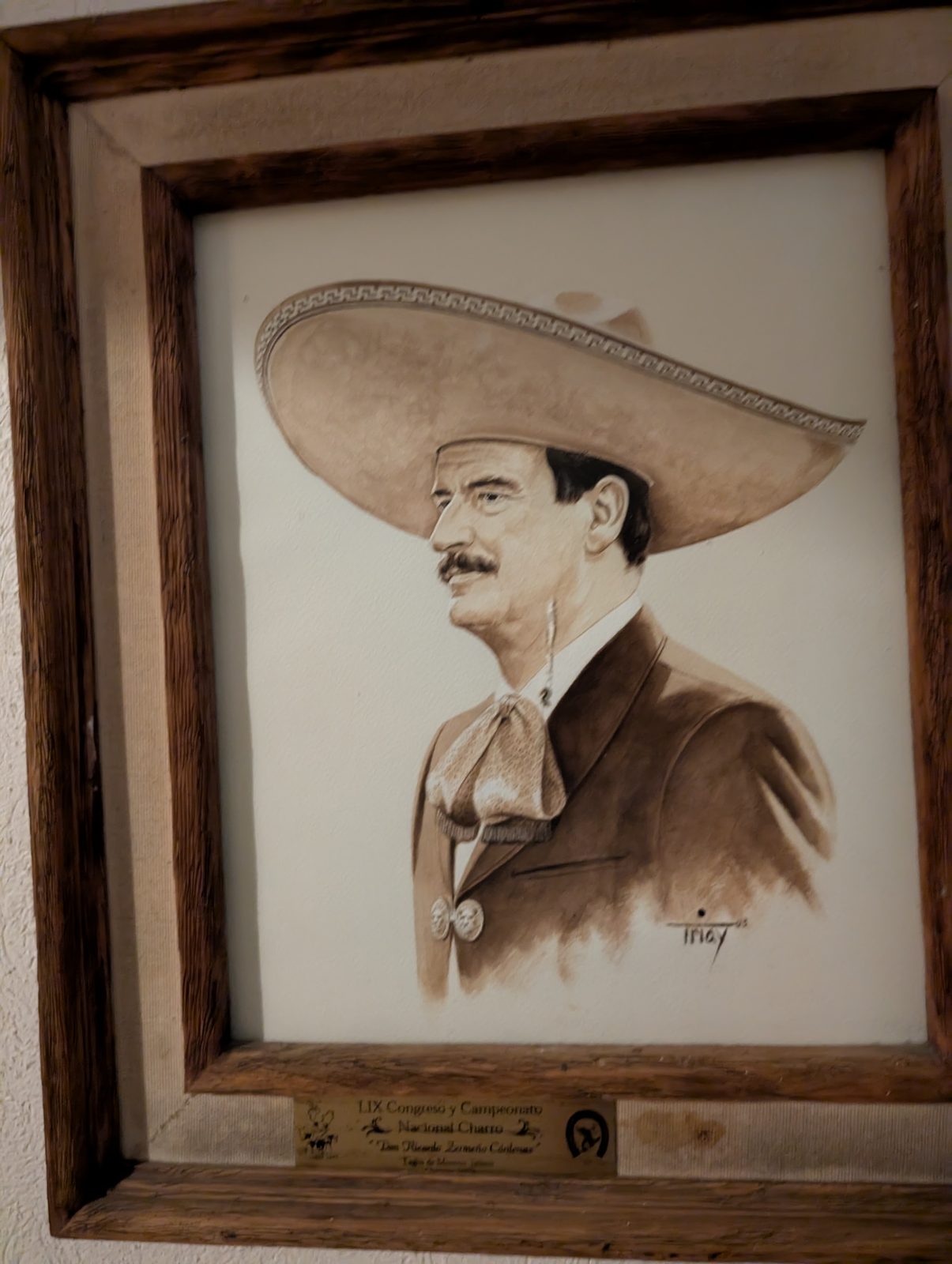A framed portrait of a champion charro in traditional dress, hanging at the hacienda restaurant