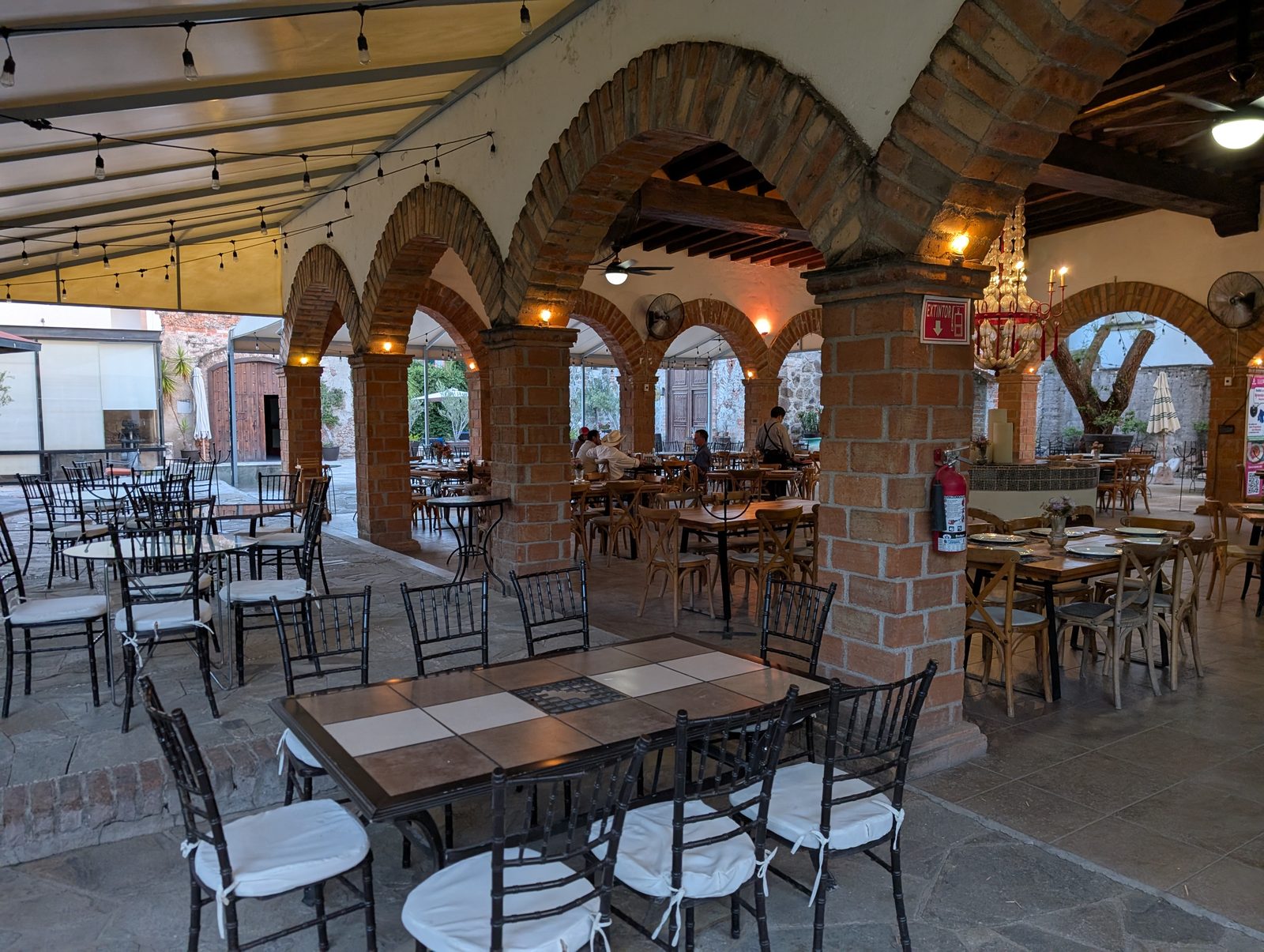 The restaurant patio at the hacienda, with brick arches and string lights overhead